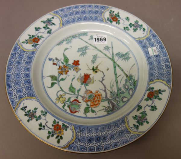 A Chinese doucai-type large plate, 18th century, painted with a small bird amongst bamboo, blossoming peony and hibiscus issuing from rockwork, the ev