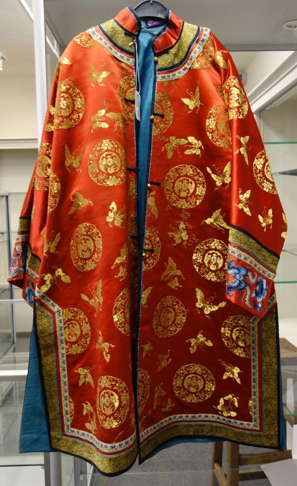 A Chinese red satin informal wedding robe, late 19th century, embroidered in gilt thread with butterflies and prunus roundels, with red sleeve bands e