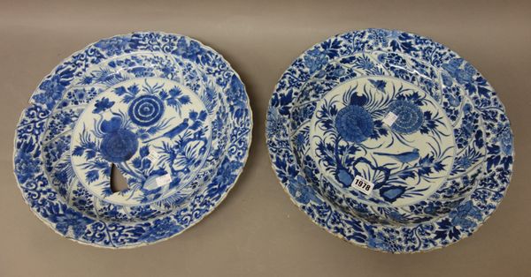 A pair of Chinese blue and white dishes, Kangxi, painted in the centre with a bird amongst flowering chrysanthemum, framed by moulded panels enclosing