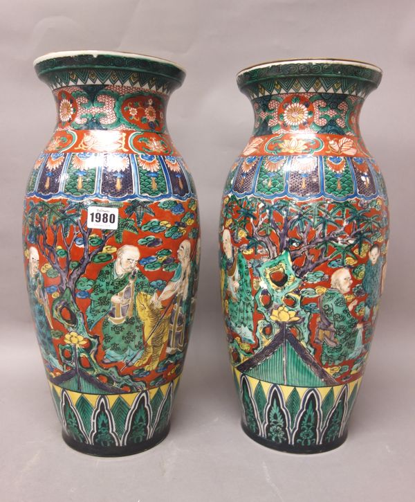 A pair of Japanese Kutani ovoid vases, 20th century, each painted with rakkan, children and animals against a red ground above a band of stiff leaves,