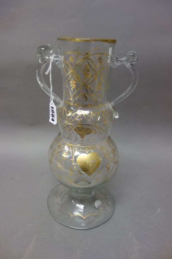 A Turkish clear and gilt glass two-handled vase, 19th century, of two-tiered bulbous form beneath a cylindrical neck, gilt with two heart shaped panel