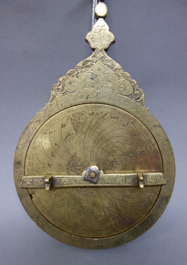 The mater and plates from a brass astrolabe, dated AH 1195/ 1780-81 AD, the brass mater with throne engraved with arabesque and calligraphic cartouche