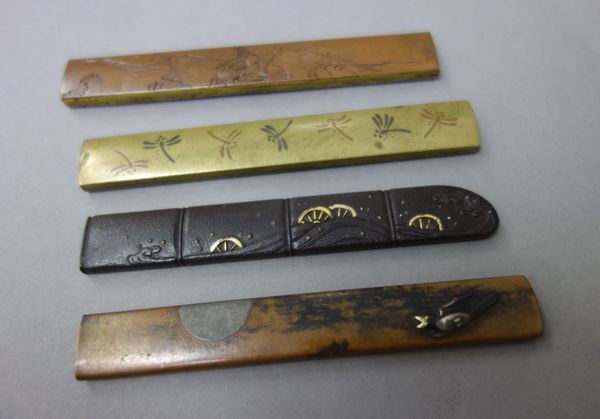 Four Japanese kozuka, Edo period, 19th century, two in copper, one in iron and one in sentoku, various inlaid designs, each approx. 9.5cm length.