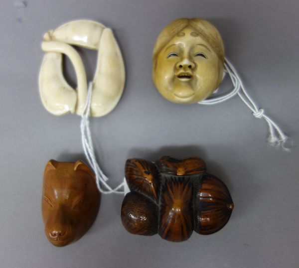 Four Japanese netsuke, Edo period, 19th century, comprising; an ivory mask of Okame, signed Shugetsu saku; a wood netsuke of a fox mask; a wood group