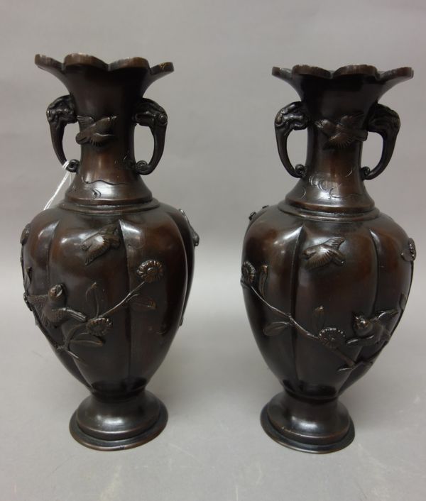 A pair of Japanese bronze two-handled vases, Meiji period, each worked in high relief with birds in branches, the waisted neck set with elephant mask