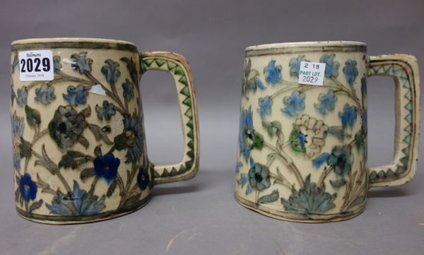 Two Persian earthenware tankards, late 19th century, of tapered cylindrical form, painted with flowers in Iznik style, 14cm. high.