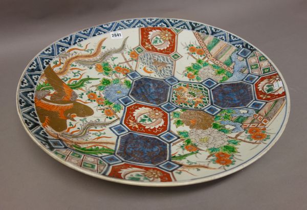 A large Japanese Imari charger, Meiji period, painted with panels enclosing a hare, birds and flowers, against a ground painted with a ho-o bird and f