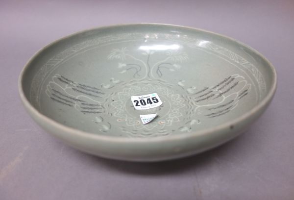 A Korean Celadon bowl, Koryo dynasty, 12th/13th century, inlaid in white and iron slip with pairs of ducks swimming between trees, the underside decor