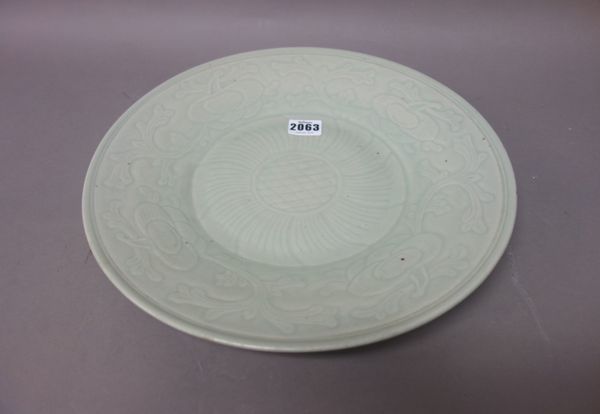 A Chinese celadon glazed dish, 18th/19th century, decorated with floral designs, 33.5cm. diameter.