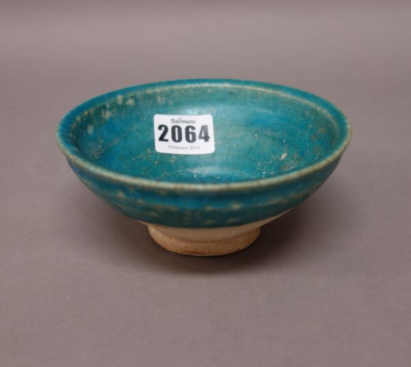 A small Persian turquoise glazed footed bowl, possibly Kashan, 12th century, 12.5cm. diameter.