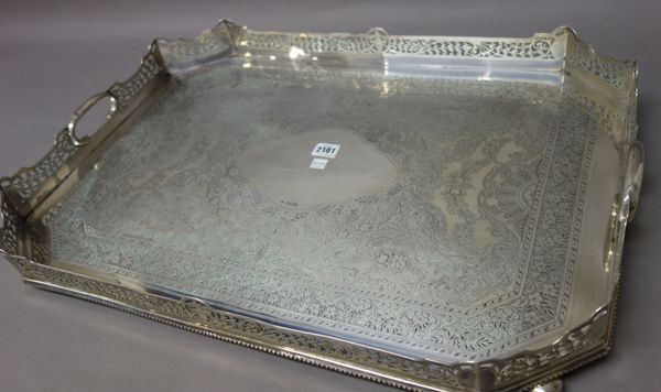 A late Victorian silver large cut cornered rectangular twin handled gallery tray, with feathered scroll, floral and foliate engraved decoration within