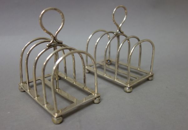 A pair of silver five bar toastracks, each of rectangular form, having a loop shaped handle and raised on four spherical feet, combined weight 187 gms