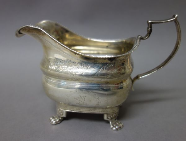 A late George III Irish silver milk jug, having a decorated rim, raised on four paw feet, Dublin 1819, weight 176 gms.