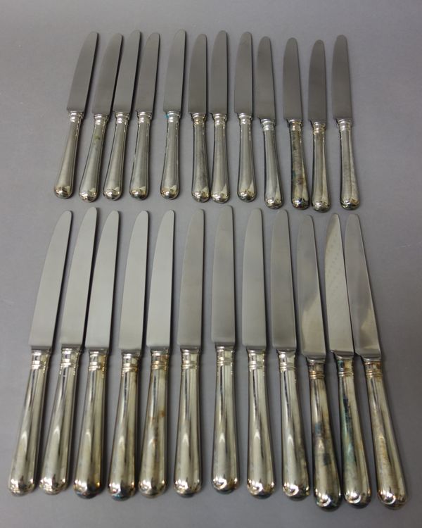 Twelve table knives, having steel blades and with loaded silver handles and twelve cheese knives, having steel blades and with loaded silver handles,