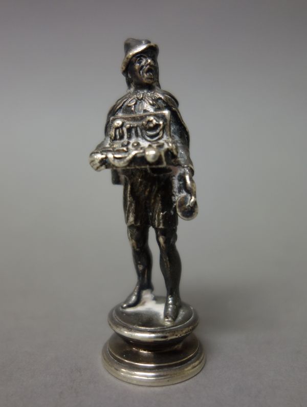 A late Victorian silver seal, modelled as the standing figure of a street vendor, monogram engraved, Sheffield 1898, height 6.5cm, weight 65gms.