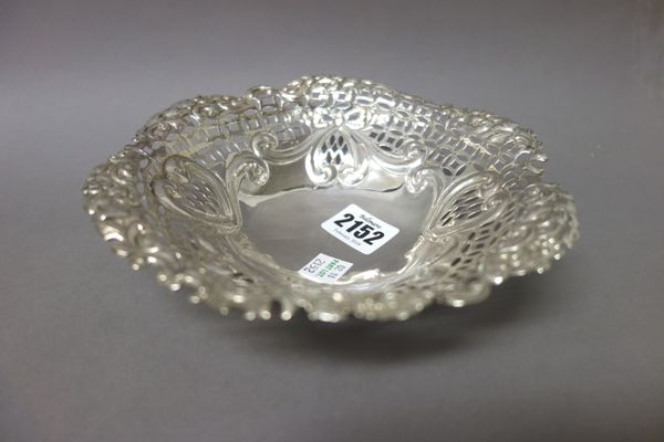 A Victorian silver shaped circular bonbon bowl, with pierced and embossed decoration, raised on three feet, Birmingham 1892, weight 145 gms and a chro