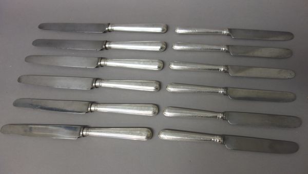 Sixteen steel bladed table knives, having loaded silver handles, the hallmarks generally worn, some London 1913 and London 1916, also fourteen steel b