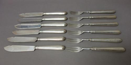 Twelve silver bladed fish knives, London 1913, having loaded silver handles, eleven silver pronged fish forks, London 1913, having loaded silver handl
