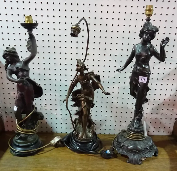 A 20th century spelter figural table lamp modelled as a woman and two similar faux metal resin examples, (3).  F9