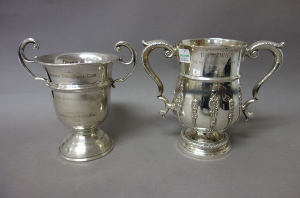 Silver, comprising; a twin handled trophy cup, in an 18th century inspired design, the hallmark rubbed and a twin handled trophy cup, Birmingham 1957,