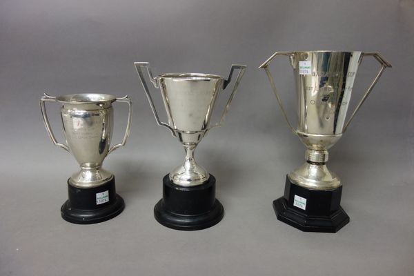 A silver twin handled trophy cup, Birmingham 1950, fitted to a black stand, a silver twin handled trophy cup, Birmingham 1937, fitted to a black stand