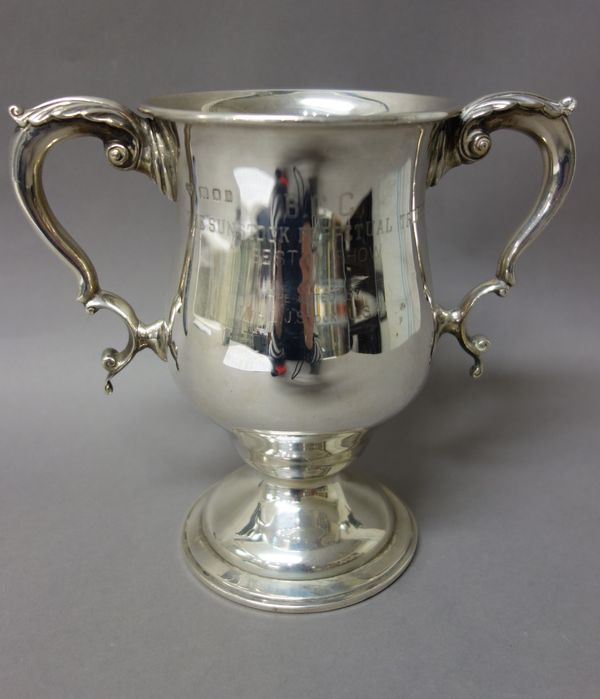 A silver twin handled trophy cup, having foliate capped handles, raised on a circular foot, presentation inscribed, London 1921, weight 721 gms, heigh