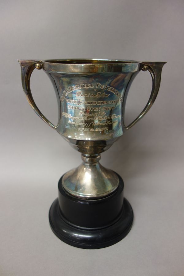 A silver twin handled trophy cup, raised on a circular foot, presentation inscribed, Birmingham 1937, weight 350 gms, height 18 cm, with a black stand