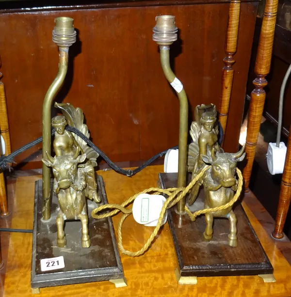 A pair of brass table lamps modelled as classical figures riding bulls, a pair of table lamps formed as Eastern deities and a resin figure lamp formed
