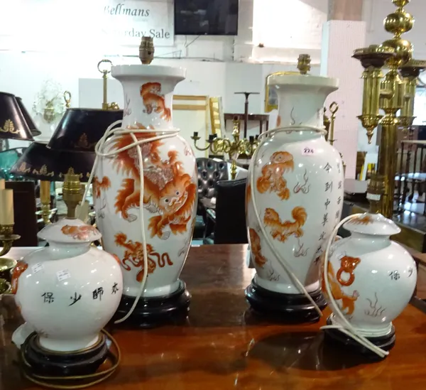 A pair of Asian ceramic vases converted to lamps, decorated with red dragons and script and a similar smaller pair, (4).  G5