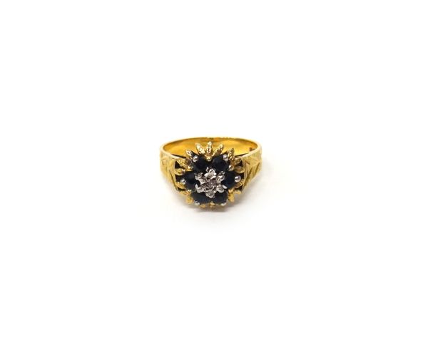 An 18 ct gold, sapphire and diamond set cluster ring, mounted with a small circuclar cut diamond at the centre, in a surround of six circular cut sapp