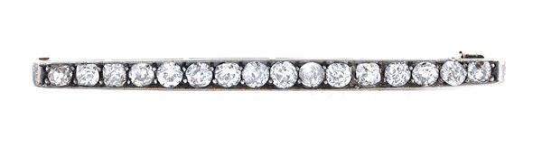 A diamond bar brooch, mounted with a row of sixteen cushion shaped diamonds, length 5.5cm.  Illustrated