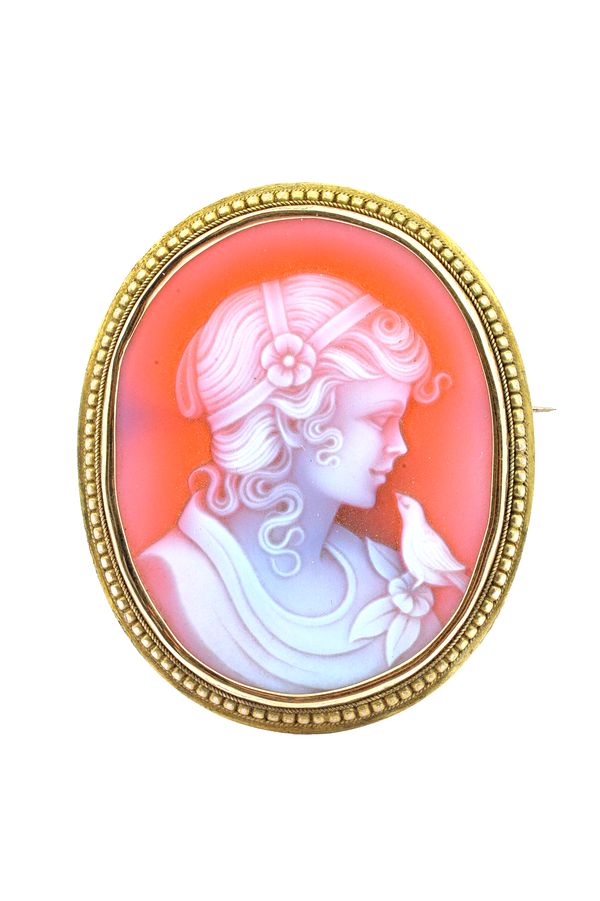 A gold mounted oval sardonyx cameo brooch, carved as the portrait of a girl with a bird, the setting having a beaded and ropetwist wirework surround,