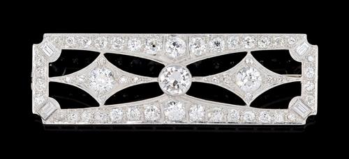A diamond brooch, pierced in a shaped rectangular Art Deco design, collet set with the principal cushion shaped diamond at the centre, between lozenge