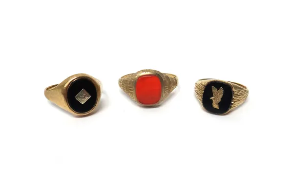 A 9ct gold and cornelian set signet ring, with facet cut decoration and two 9ct gold and black onyx set signet rings, gross combined weight 11.2 gms,