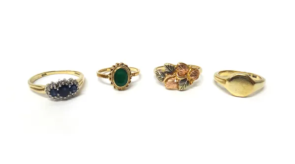 A 9ct gold ring, claw set with three oval cut sapphires, within a surround of circular cut diamonds, a 9ct gold ring, mounted with an oval cut emerald