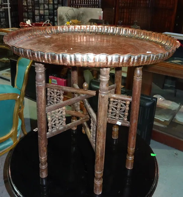 An Eastern embossed copper tray table and stand and a cream printed oval metal tray.  D3