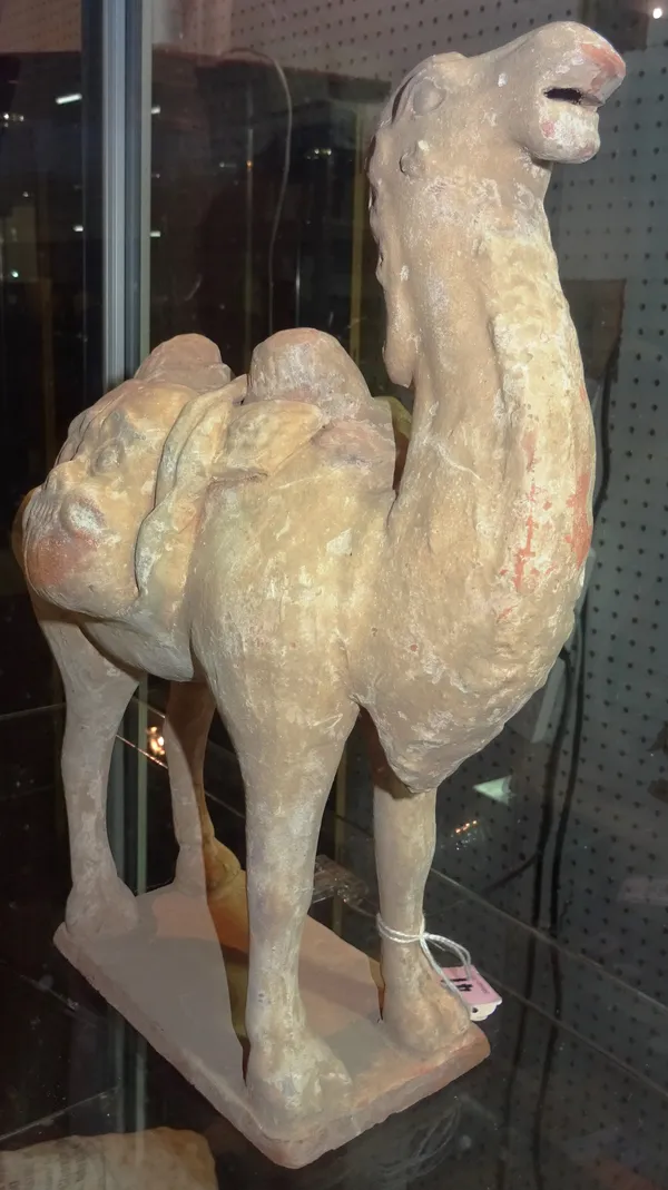 A Tang style pottery Bactrian camel, standing four square with head raised, its saddle laden with travel supplies, 30cm high, cased.