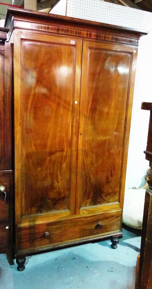 A Victorian walnut double wardrobe over a single drawer base on turned supports, 113cm wide x 210cm high.  M6