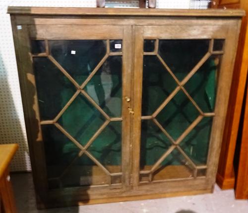 An early 20th century oak gun cabinet with astragal glazed doors, 131cm wide x 133cm high.  M8