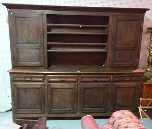 An early 19th century Continental oak dresser with a three tier plate rack flanked by cupboard doors over four drawer and cupboard base, 263cm wide x