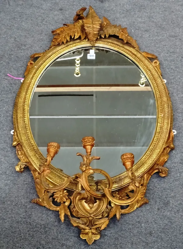 A Victorian gilt framed three branch girandole wall mirror with fern moulded crest and oval plate, 63cm wide x 115cm high.  M5