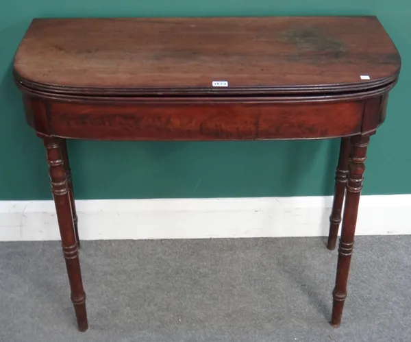 A Regency mahogany card table, the 'D' shaped top on turned supports, 91cm wide x 45cm deep x 75cm high.  I6