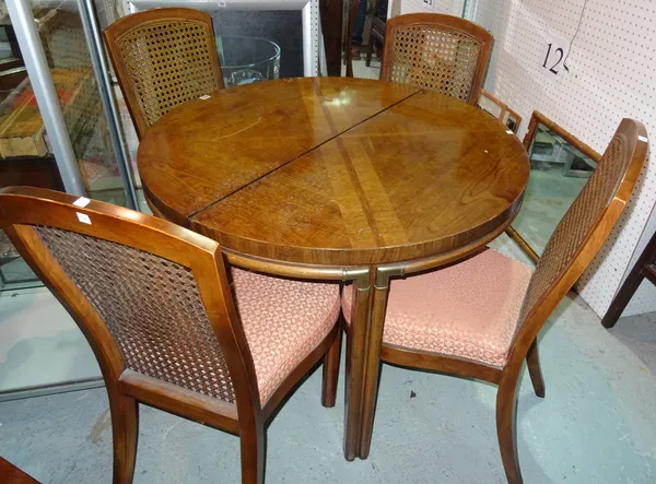 A 20th century oak circular extending dining table with two extra leaves, and a set of four caned back dining chairs, 103cm wide x 75cm high x 205cm l