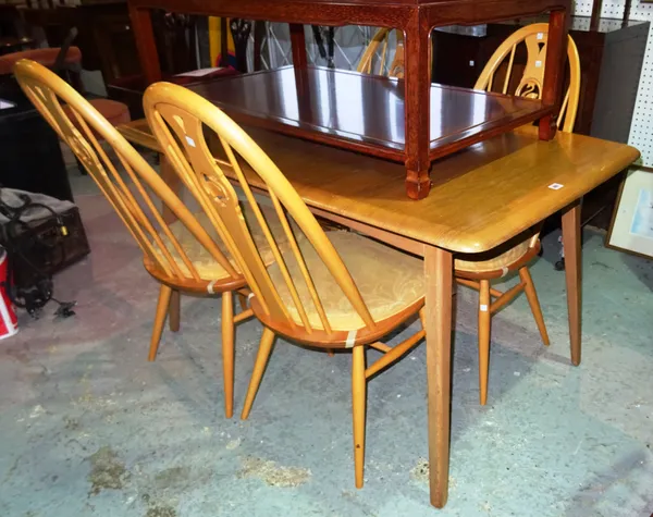 Ercol; a 20th century oak extending dining table with one internal leaf and a set of four stick back dining chairs, 136cm wide x 76cm high x 141cm ful