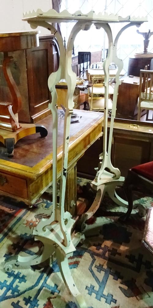 A pair of Continental cream painted torchère stands, each with hexagonal top over three pillar column, on scroll supports, 35cm wide x 145cm high, (2)