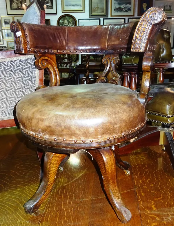 A Victorian oak tub back office open armchair, with brown leather upholstery.  E6