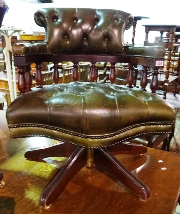 A 20th century mahogany office swivel armchair, with green button back leather upholstery.  E6