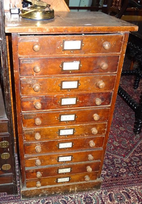 An early 20th century stained pine floor standing chest of ten drawers, with turned handles and plinth base, 52cm wide.  F7