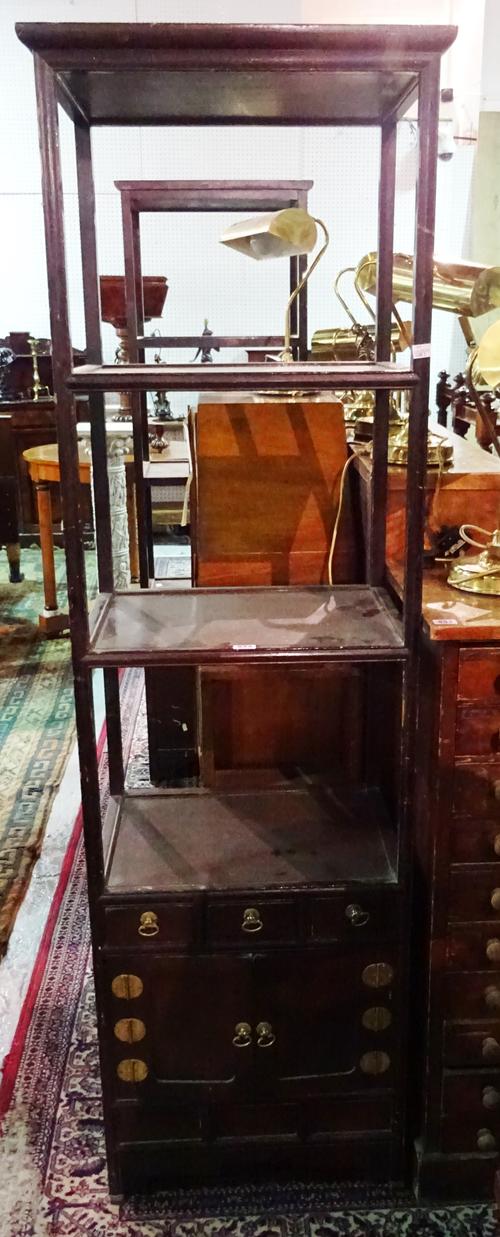 A pair of early 20th century Chinese four tier what-nots, each with cupboard base, 52cm wide x 170cm high, (2).  F7