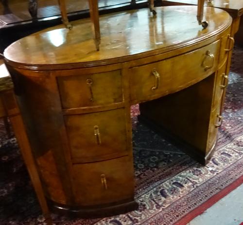 An early 20th century oval pollard oak writing desk, with seven drawers about the knee, on an ebonised plinth base, 113cm wide x 76cm high.  G7